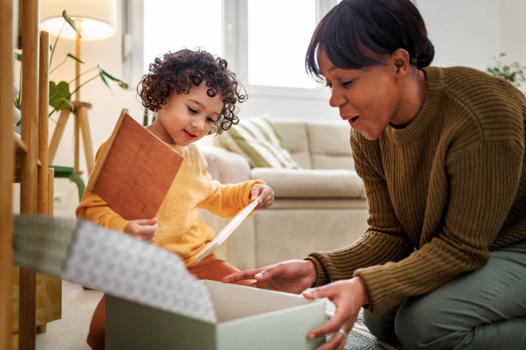 happy mum and child opening present istock 2131026824
